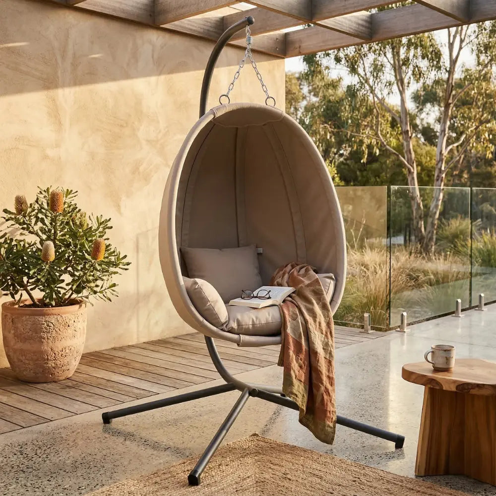 Taupe Hanging Egg Chair with Stand and Cushion on Patio